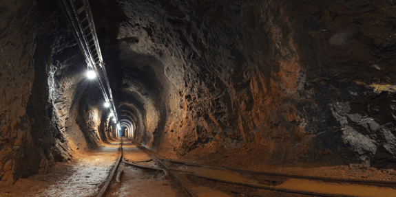underground mine passage with rails and lights