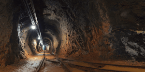 underground mine passage with rails and lights